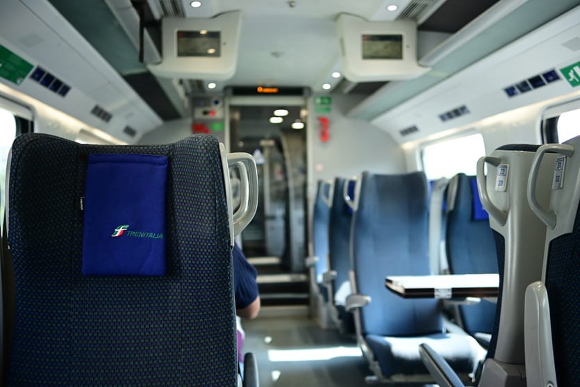 A picture of a Frecciargento train, with almost no people in the carriage.