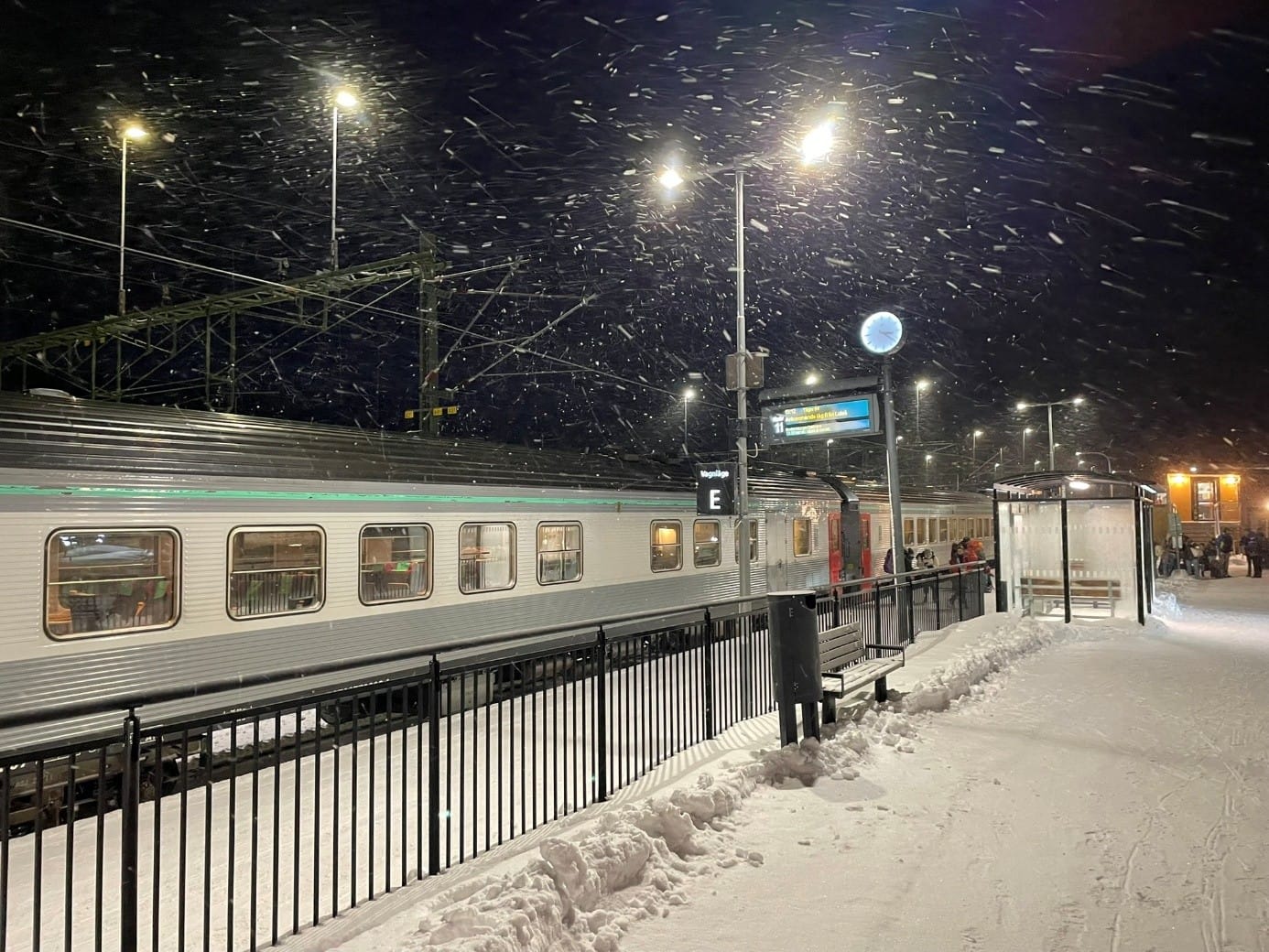 Ein Nachtzug an einem Bahnhof im Schneegestöber