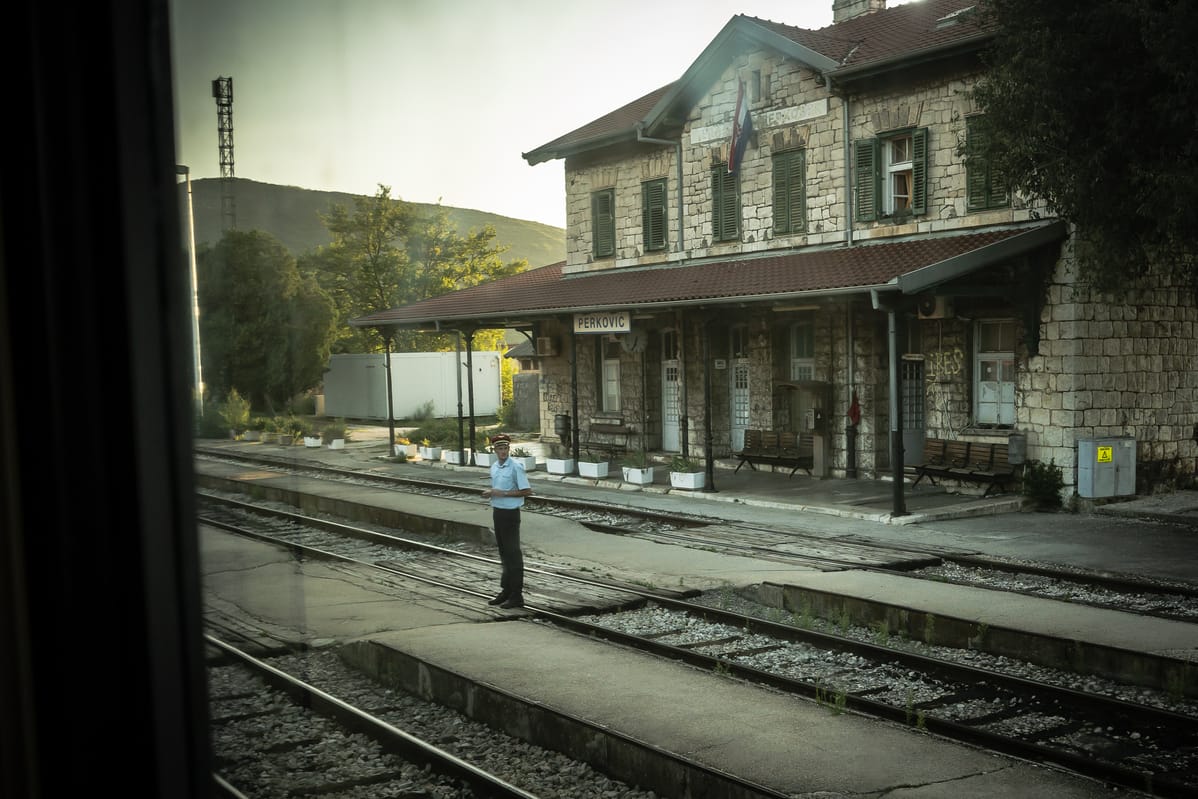 Ein Bahnhofvorsteher steht am Bahnhof Perkovic