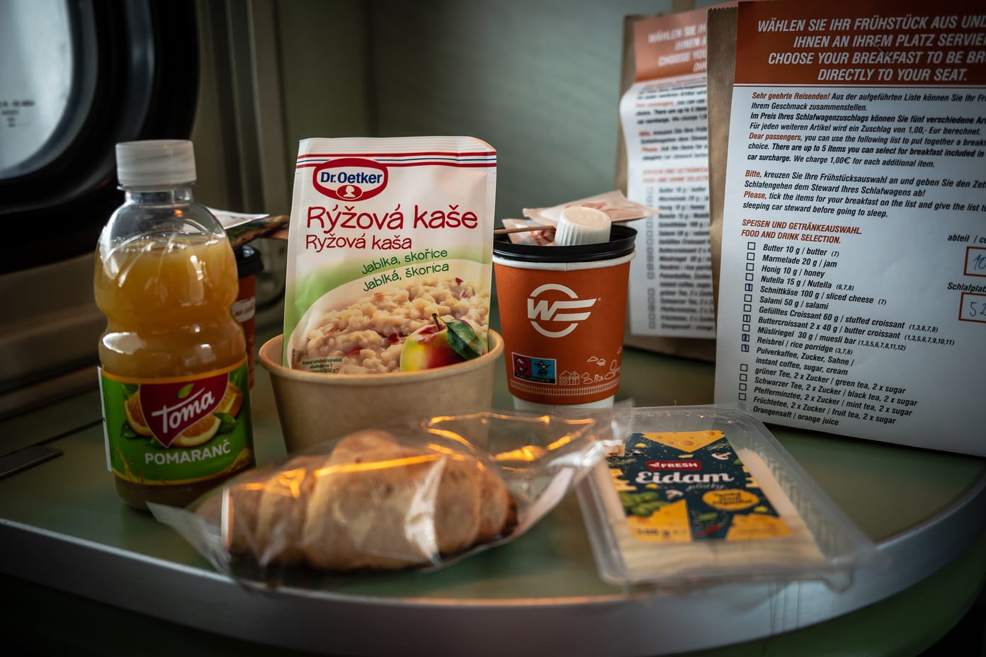 Das Frühstück mit Saft, Milchreis, Croissant und Käse