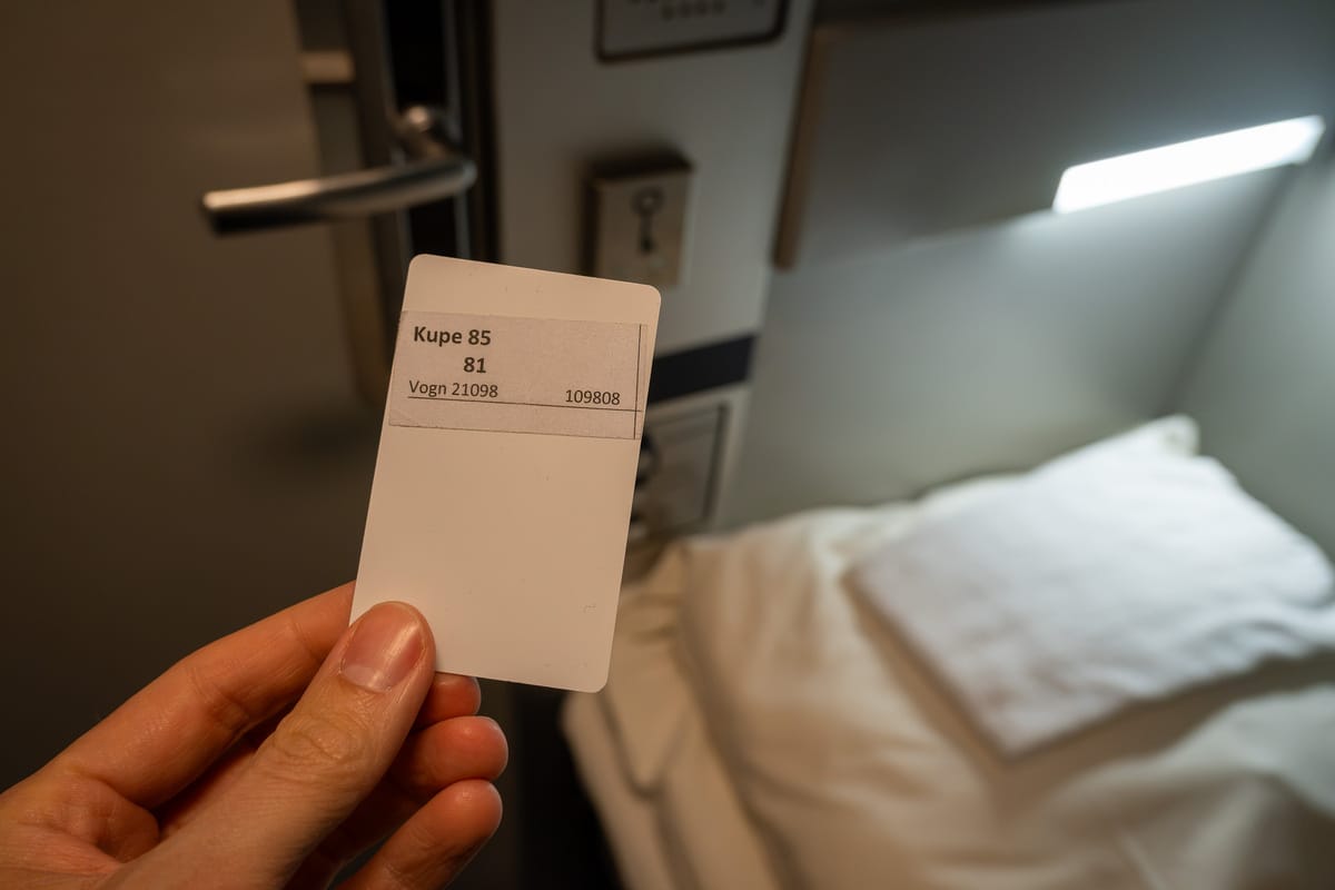 Une main tient la carte-clé du compartiment de voiture-lit