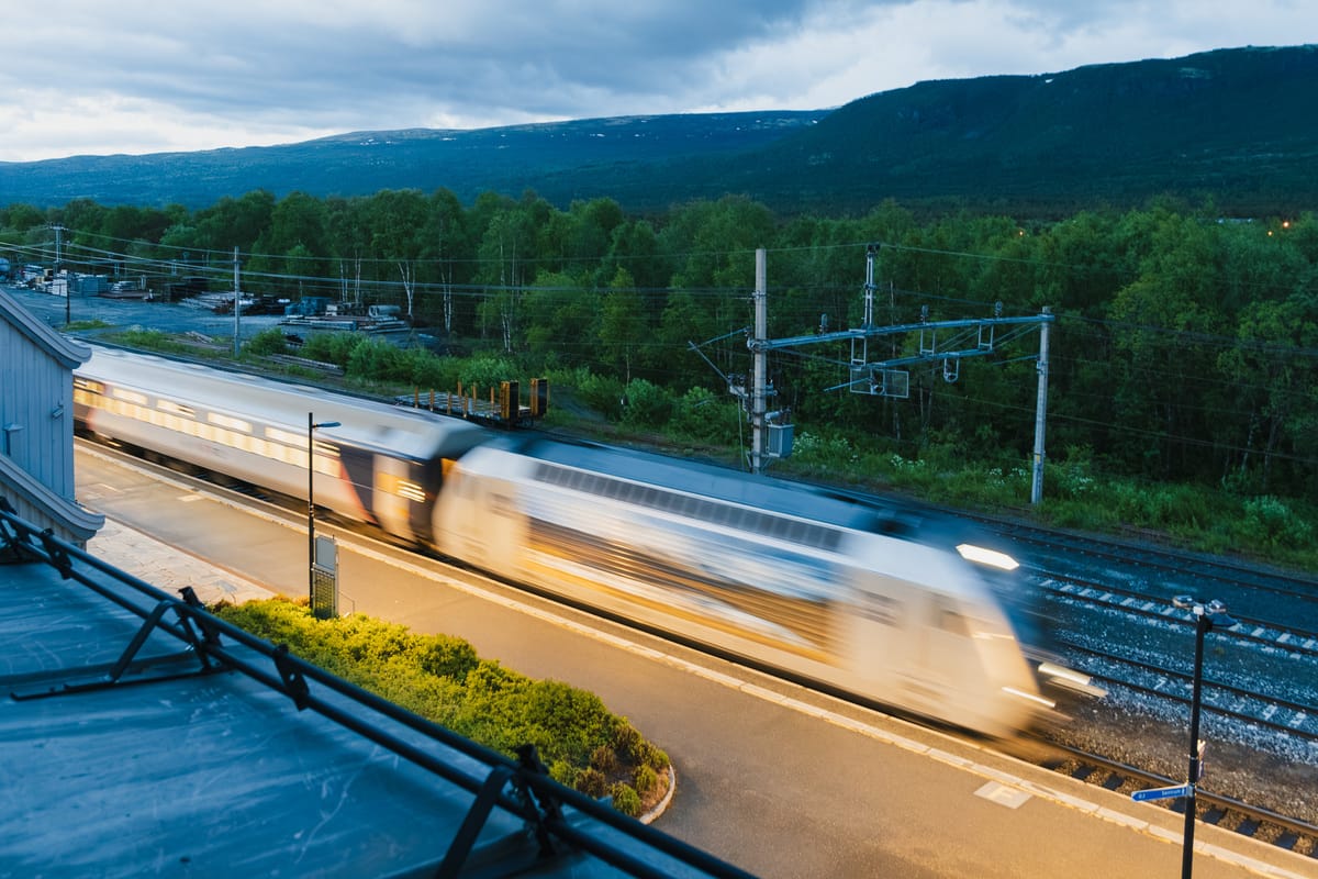 Un train de nuit traverse les montagnes norvégiennes au crépuscule